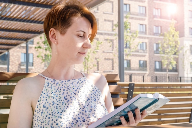 Vrouw leest een boek in de buurt van het kantoor tijdens een werkpauze