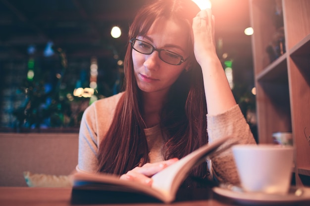 Vrouw leest een boek in een café