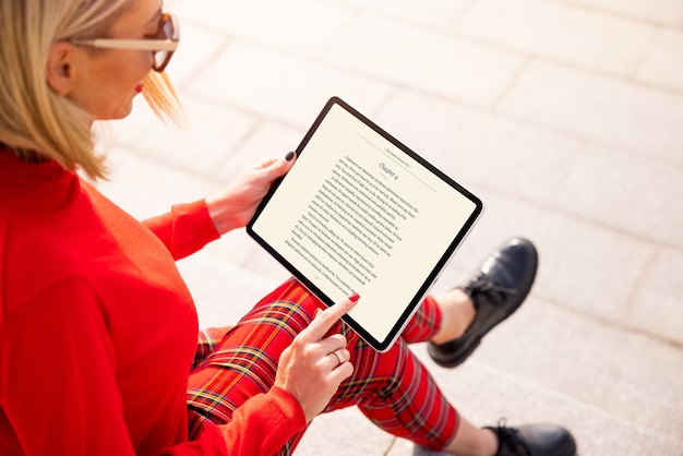 Vrouw leest een boek op tablet Tekst op het scherm is volledig verzonnen