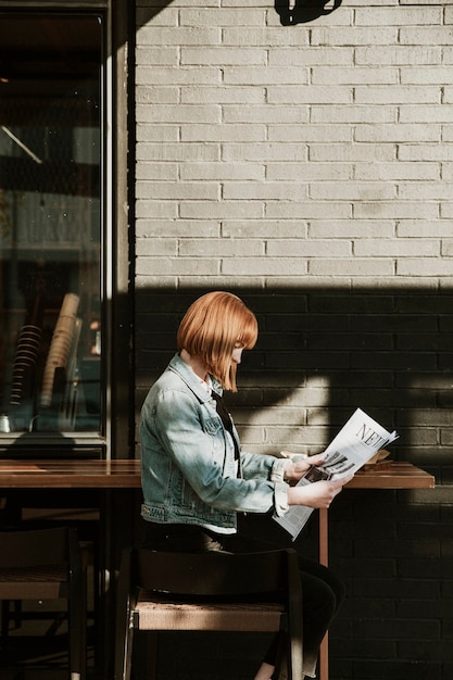 Vrouw leest een krant in een café