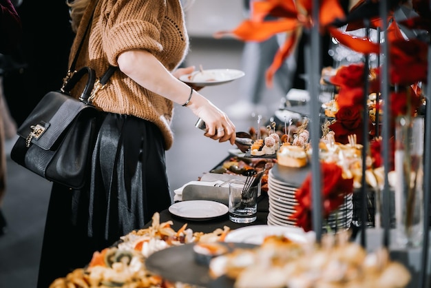 vrouw legt eten van tafel met hapjesbuffet