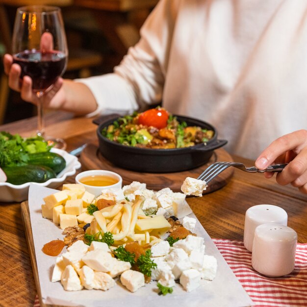 Vrouw lekker vlees eten op de houten plaat met rode wijn, bovenaanzicht