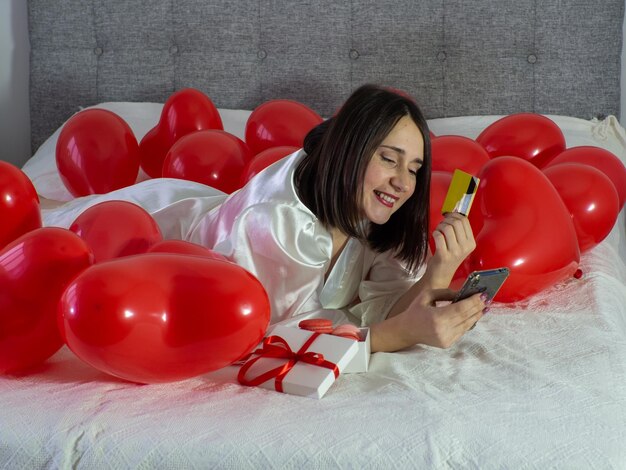 Vrouw liggend in decoraties met ballonnen voor Valentijnsdag feest