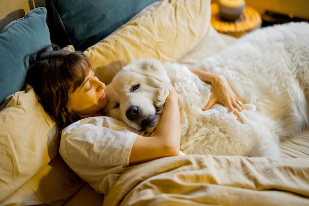 Vrouw liggend met haar grote en schattige hond in bed