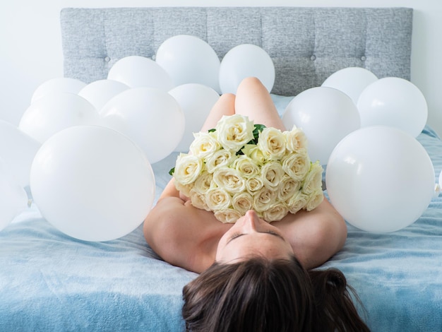 Vrouw liggend op bed met versieringen met ballonnen voor verjaardagsfeestje