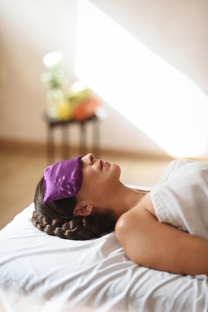 Foto vrouw liggend voor massage met zaadzakje op ogen in verticaal vlak