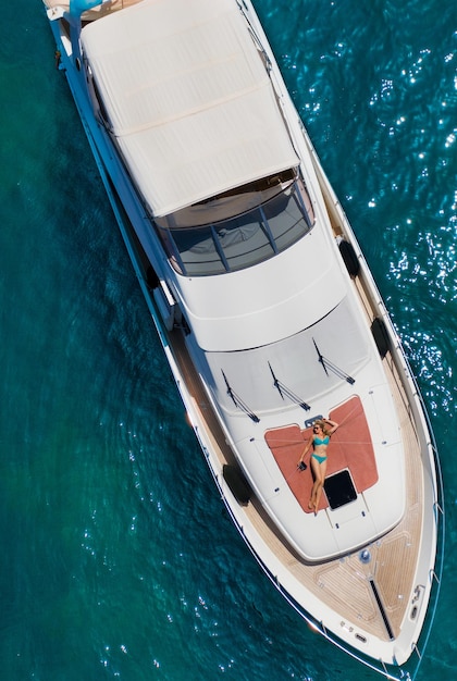 Vrouw ligt op het dek van een boot op zee