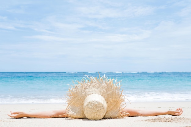 Vrouw ligt op het witte zand op het strand