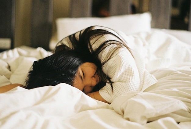 Vrouw ligt thuis op bed.