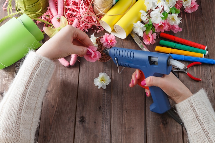 Foto vrouw lijm handgemaakte bloemen met smeltpistool