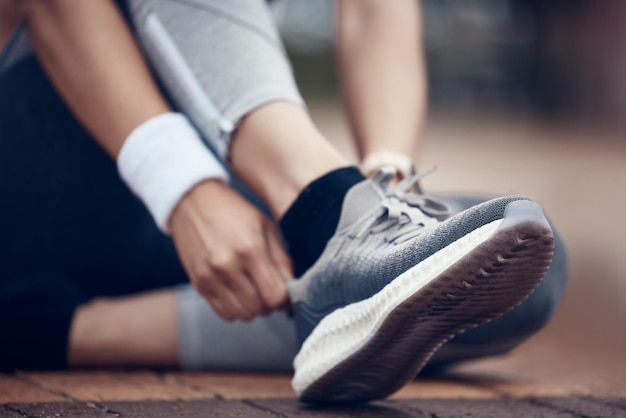 Vrouw loopschoenen en stadsfitness voor training oefening en training in wellness gezondheid hart cardio of marathon Zoom sporttrainers en runner handen klaar voor stedelijke activiteit energie of doelen