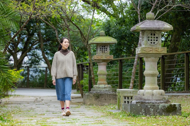 Vrouw loopt in de Japanse groene tuin