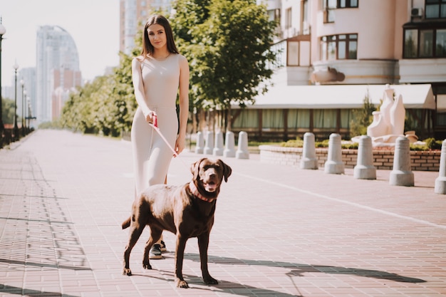 Vrouw loopt met haar hond op de stadspromenade