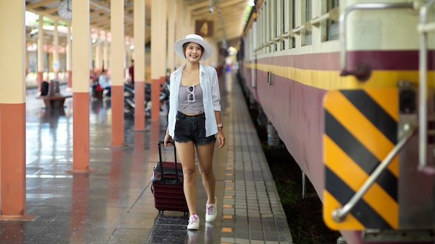 Vrouw loopt op de trein op het platform van het treinstation