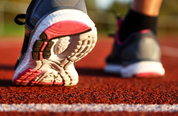 Foto vrouw loopt 's middags op atletiekbaan