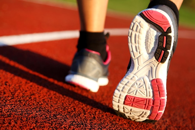 Vrouw loopt 's middags op atletiekbaan