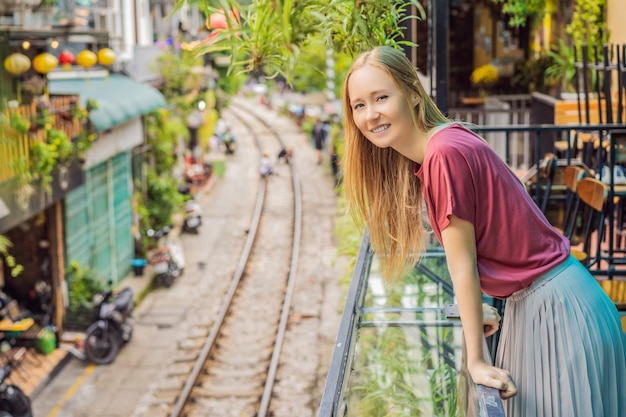 Vrouw loopt van Hanoi stad spoorweg perspectief uitzicht loopt langs een smalle straat met huizen in