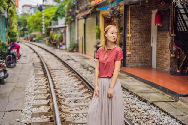 Vrouw loopt van Hanoi stad spoorweg perspectief uitzicht loopt langs een smalle straat met huizen in