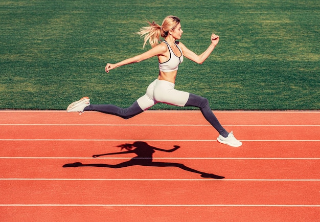Vrouw lopende sprong op stadion spoor Sportvrouw in sportkleding springen Vrouw loopt tijdens Sport achtergronden Runner
