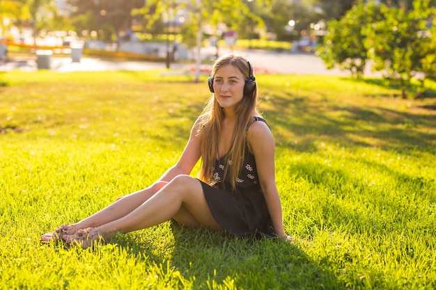 Vrouw luistert naar de muziek op het gras