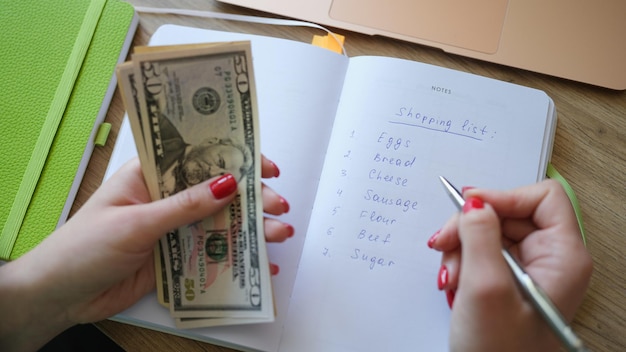 Vrouw maakt boodschappenlijstje en houdt geldwinkelplanning vast in winkelconcept