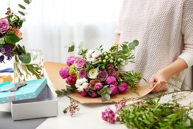 Vrouw maakt een boeket bloemen