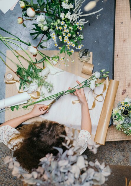 Foto vrouw maakt een boeket bloemen