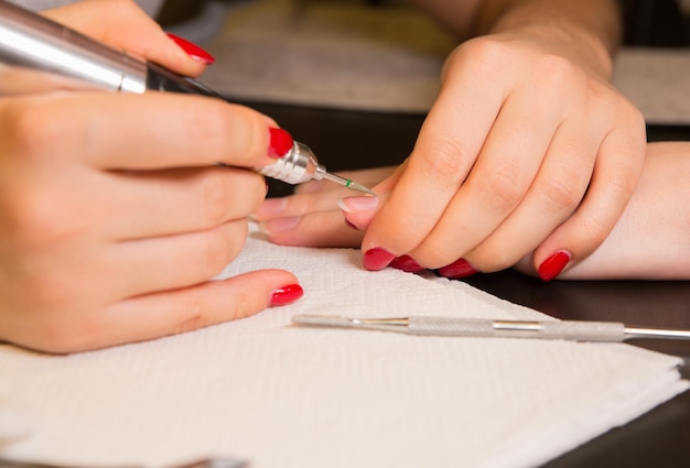 Vrouw maakt een manicure Salonprocedures thuis Mooie handen en nagels