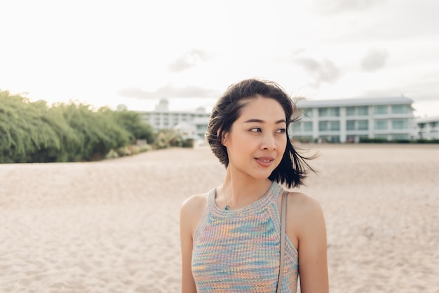 Vrouw maakt een wandeling op het winderige strand en de zonnige zon