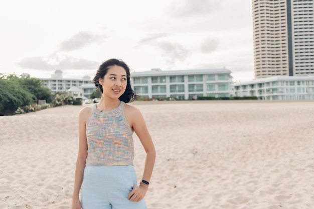 Vrouw maakt een wandeling op het winderige strand en de zonnige zon.