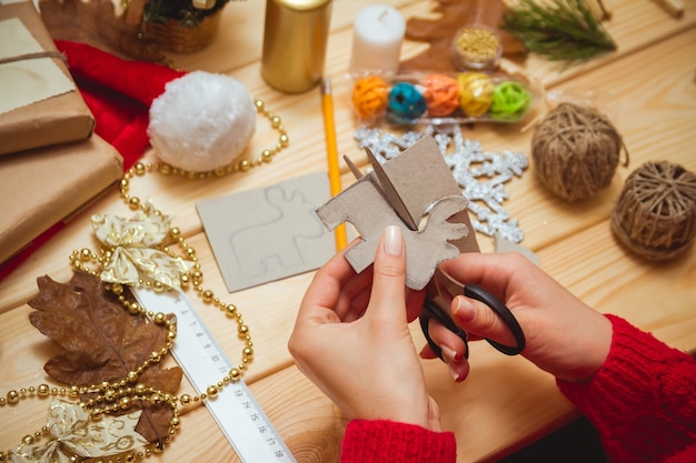 Foto vrouw maakt kerstaccessoires