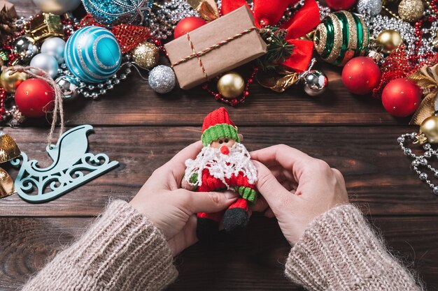 Vrouw maakt kerstcadeaus op een donkere houten tafel.