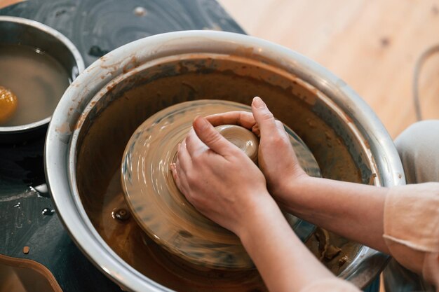 Vrouw maakt pot uit klei in de werkplaats Close Up view