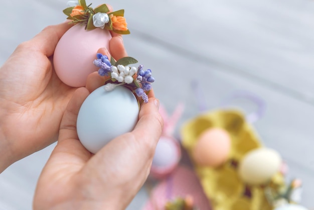 Vrouw maakt schattige decoratieve eieren voor paasvakantie. doe-het-zelf paasgeschenken concept. schattige pastelkleurige eieren