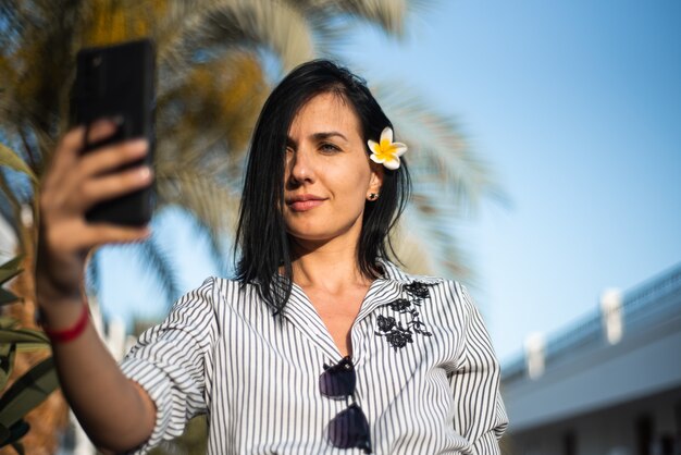 Vrouw maakt selfie in tuin met bloemen