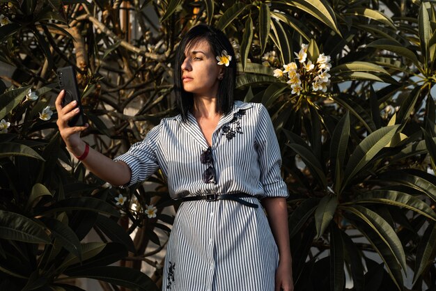 Vrouw maakt selfie in tuin met bloemen