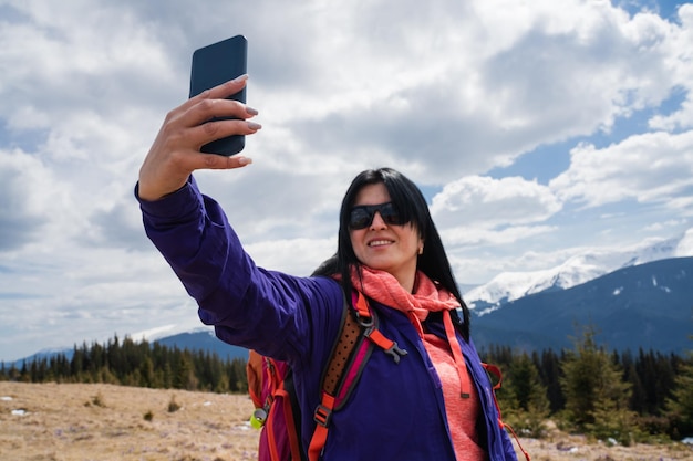 Vrouw maakt zelfportret tijdens een bergwandeling