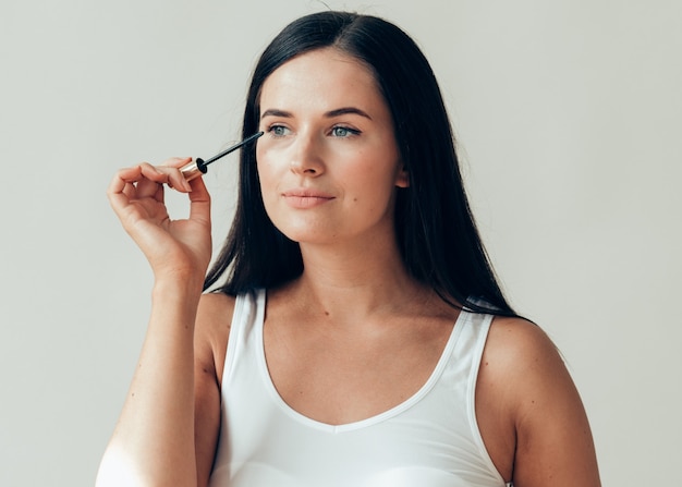 Vrouw make-up mascara ogen gezonde huid natuurlijke mode make-up. Studio opname.