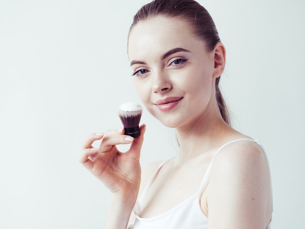 Vrouw make-up poeder huid gezicht mooi vrouwelijk natuurlijk portret toepassen.