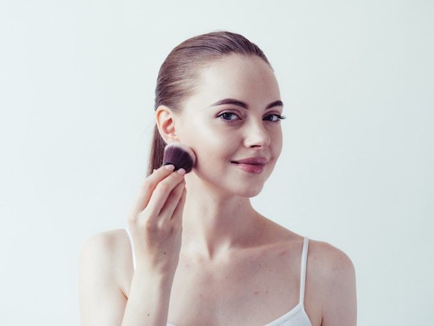 Vrouw make-up poeder huid gezicht mooi vrouwelijk natuurlijk portret toepassen.