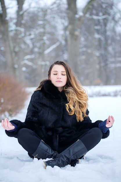 Vrouw mediteert in de winter