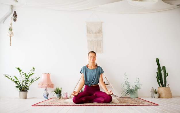 Vrouw mediteert in lotushouding in een yogastudio