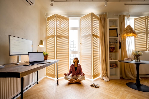 Vrouw mediteert op kantoor aan huis