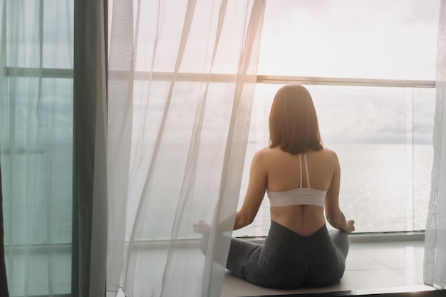 Vrouw mediteert yoga asana op het balkon in de ochtend