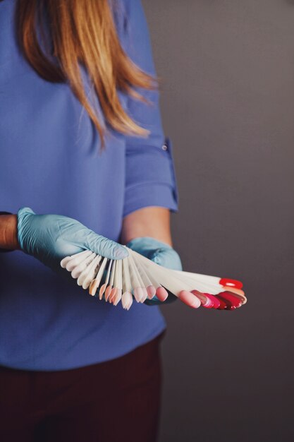 Vrouw meester in schoonheidssalon voert kleurtest van nagellakken uit