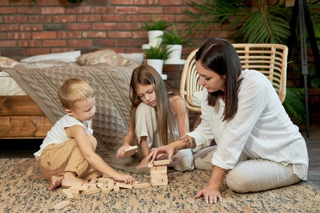 Vrouw meisje en jongen spelen familie puzzelspel