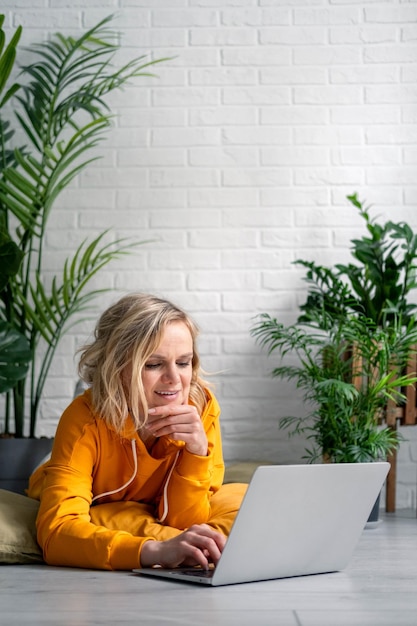 Vrouw meisje met behulp van computer laptop werken kantoorwerk op afstand van huis stedelijke jungle huis planten Afstandsonderwijs online onderwijs en werk