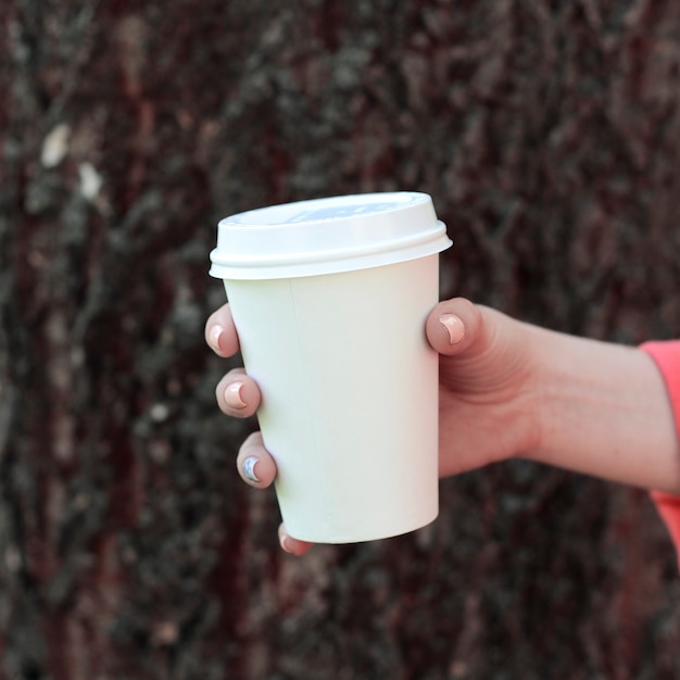 Vrouw met afhaalkoffie in het park