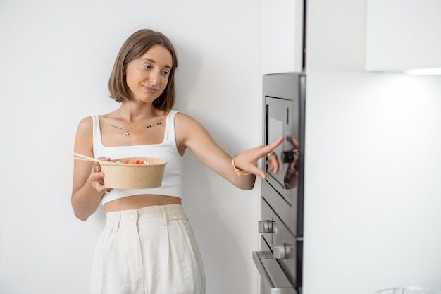 Vrouw met afhaalmaaltijden op de moderne keuken thuis