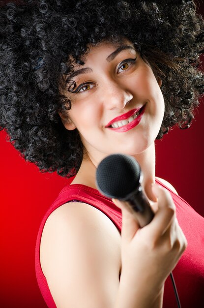 Vrouw met afro kapsel zingen in karaoke